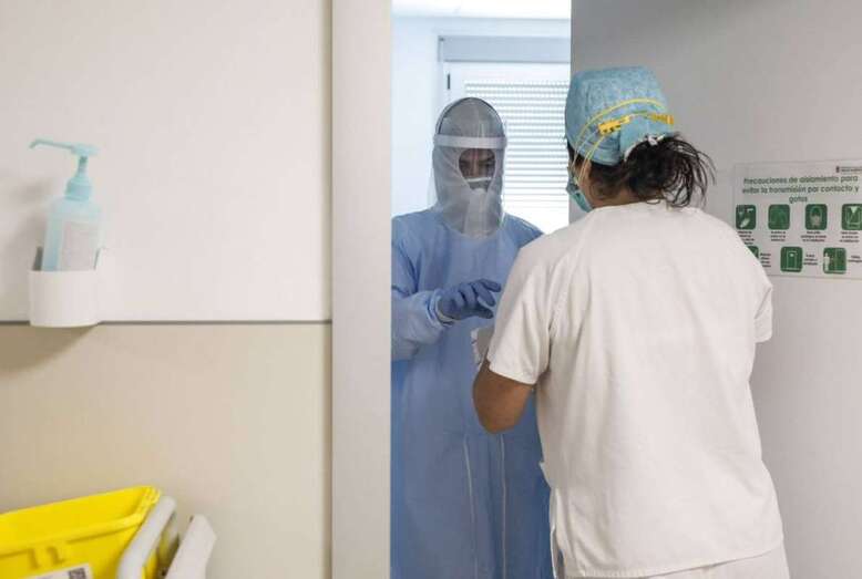Trabajadores sanitarios entran en la habitación de un paciente negativo de Covid-19 en un hospital (Foto Europa Press)